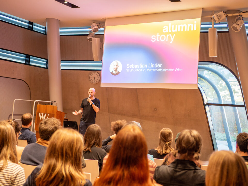 Sebastian Linder on stage presenting his alumni story